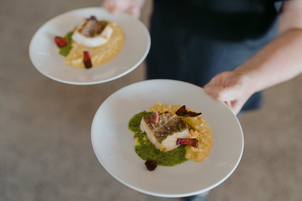 A person carrying two plated desserts