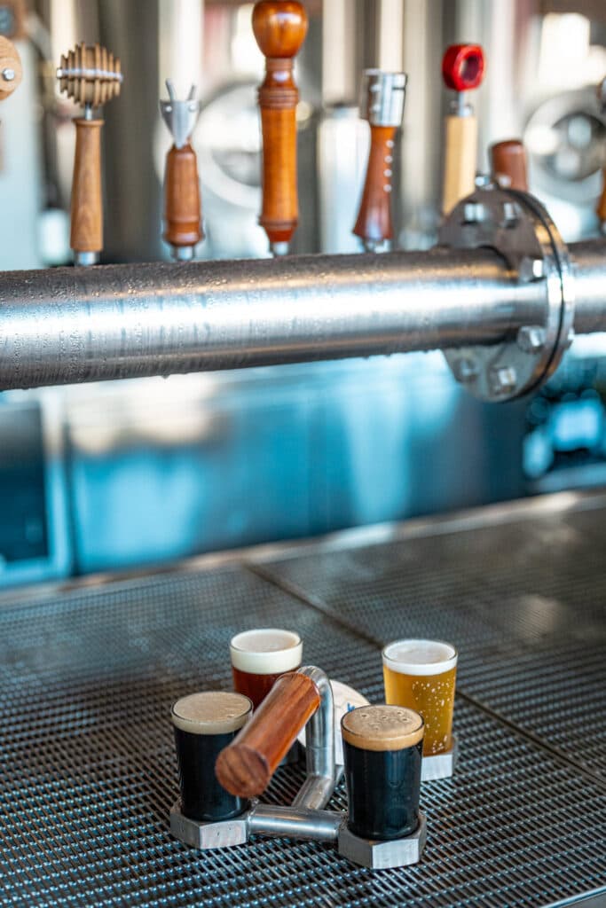 A beer tasting paddle beneath a row of bar taps