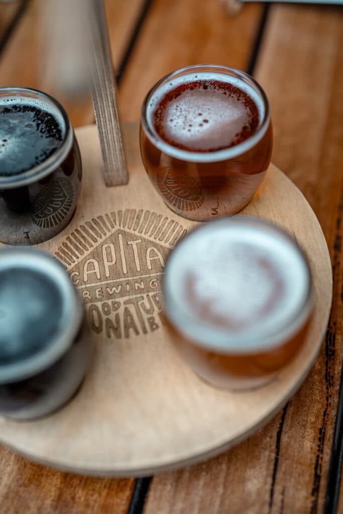 Four beer samples viewed from above on a wooden paddle
