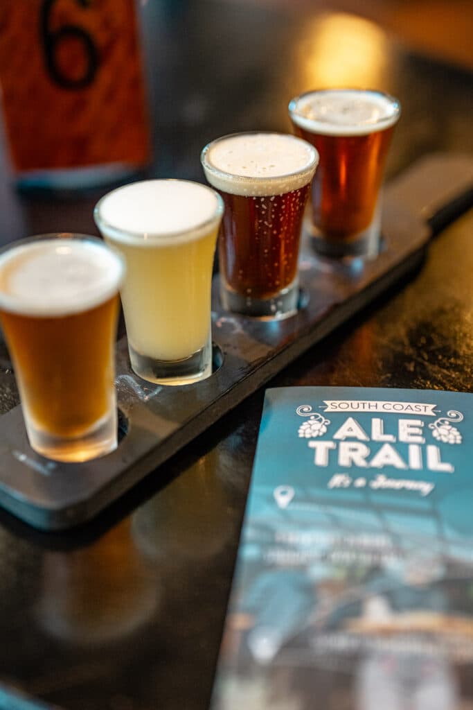 A row of four beer samples on a tasting paddle