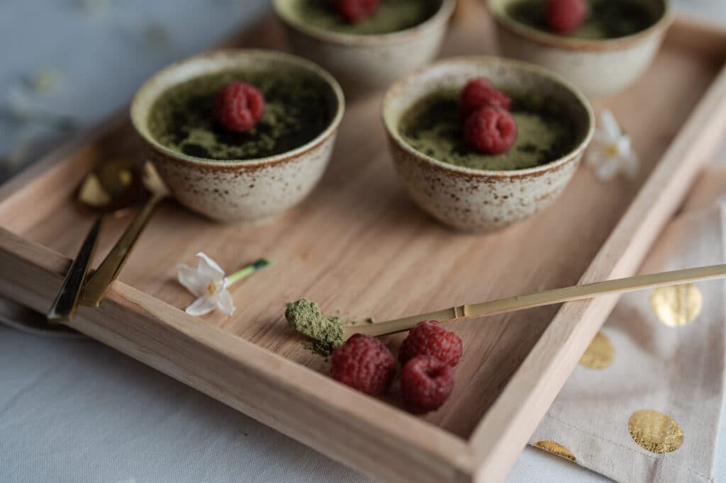 Two small dessert bowls topped with raspberries