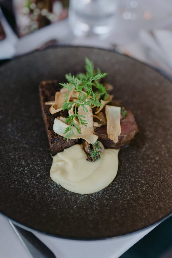 A plated dish with leafy garnish and pale sauce