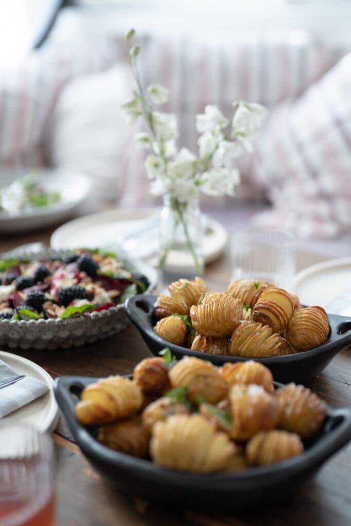 Trays of pastries beside a tart and a vase of flowers